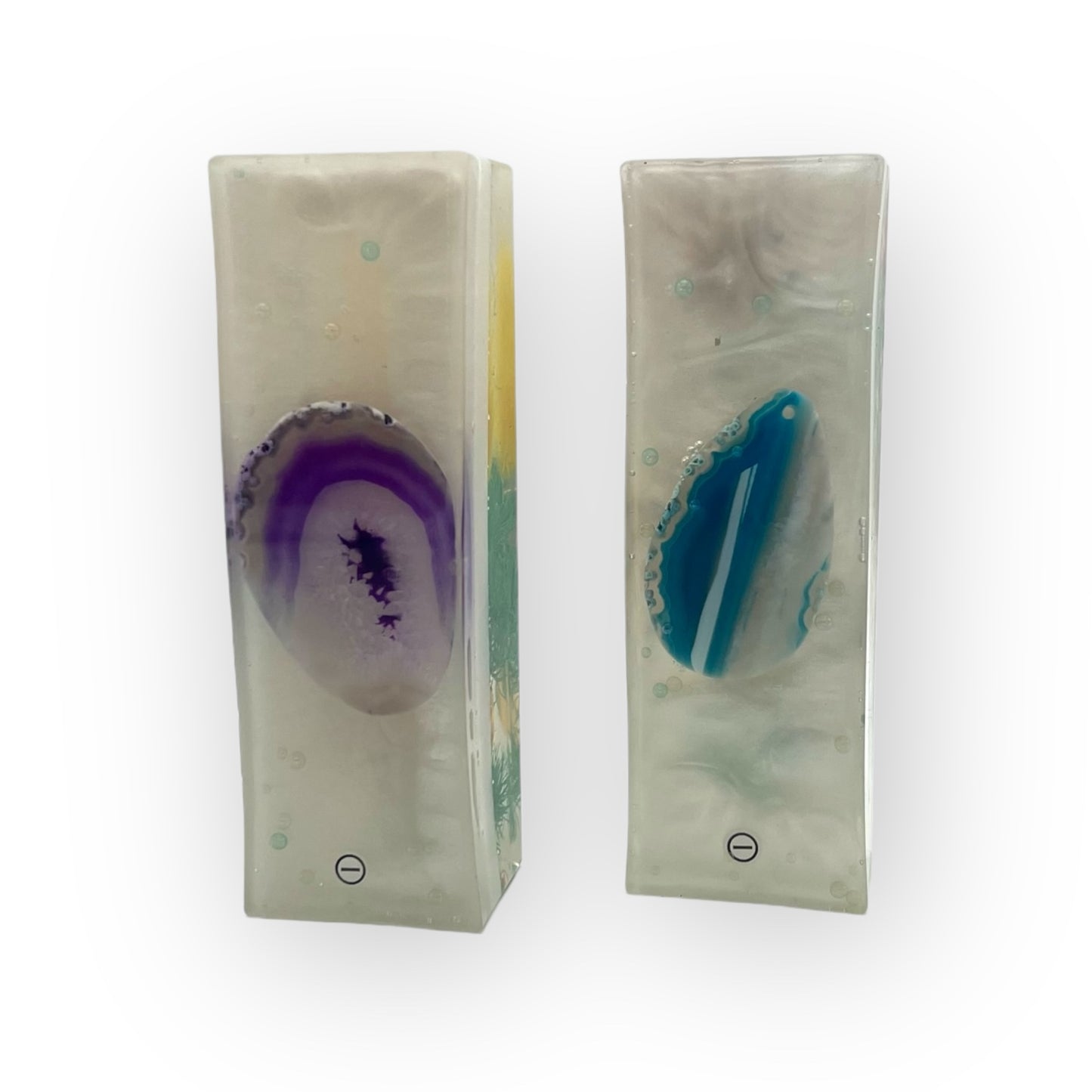 Zwei handgefertigte Harmonie-Säulen aus Magneten auf einem Nachttisch, entworfen, um den natürlichen Energiefluss im Raum zu harmonisieren und eine beruhigende Atmosphäre für besseren Schlaf zu schaffen.