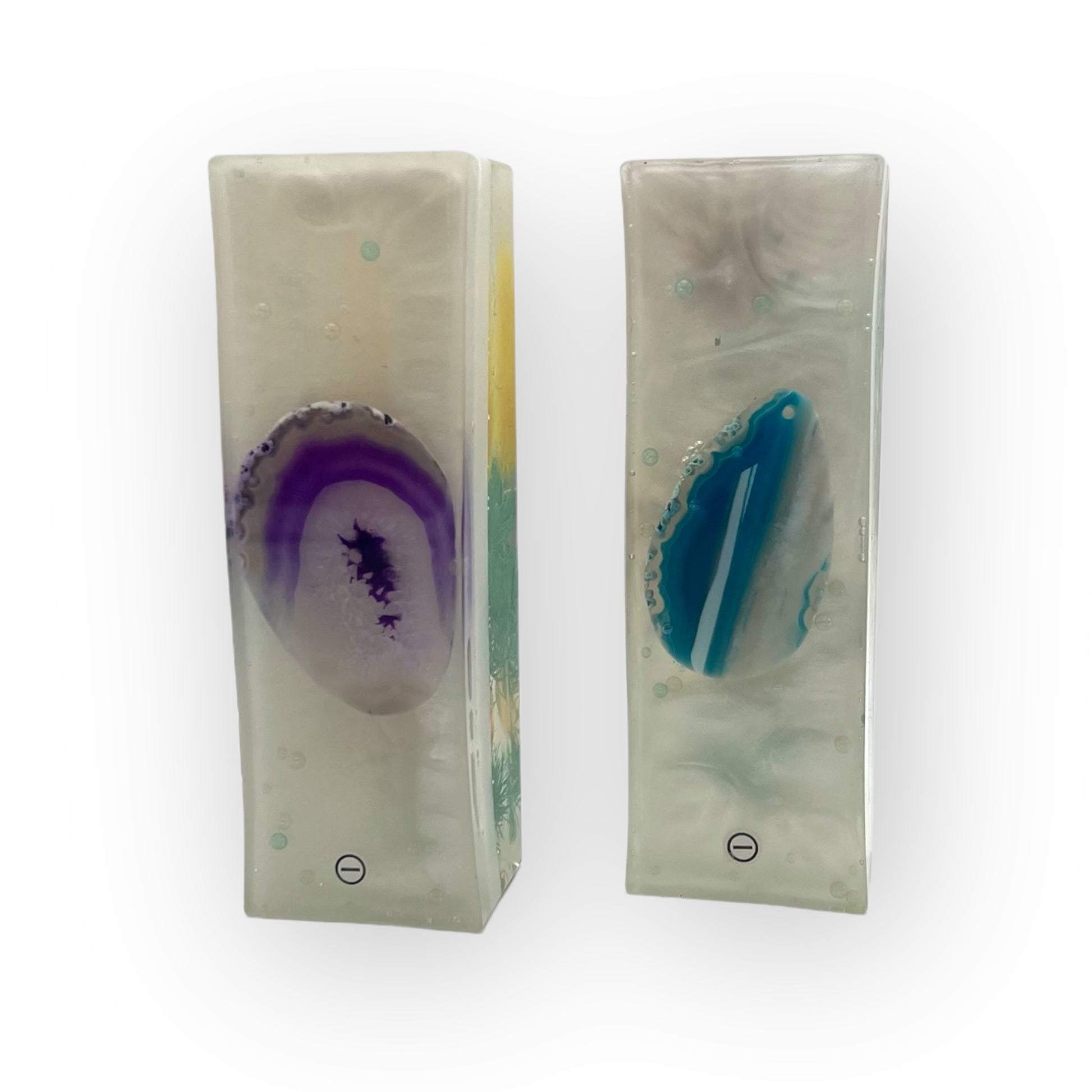 Zwei handgefertigte Harmonie-Säulen aus Magneten auf einem Nachttisch, entworfen, um den natürlichen Energiefluss im Raum zu harmonisieren und eine beruhigende Atmosphäre für besseren Schlaf zu schaffen.